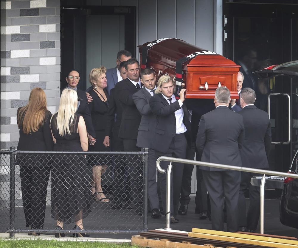 The coffin of Shane Warne is carried out by his son Jackson following a funeral service in Melbourne, Australia, Sunday, March 20, 2022. Warne’s family and friends have attended a private funeral in his hometown of Melbourne to pay their final respects to the cricketing legend. (David Caird/Pool Photo via AP)