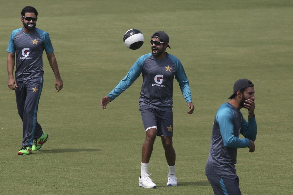 Pakistan's skipper Babar Azam, center, play with a soccer ball at the Gaddafi Stadium in Lahore, Pakistan, Sunday, March 20, 2022. Pakistan and Australia will play third test match on March 21. (AP Photo/K.M. Chaudary)