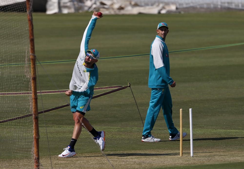 Australia's Nathan Lyon, left, bowls while teammate Ashton Agar watches during practice session at the Pindi Cricket Stadium, in Rawalpindi, Pakistan, Tuesday, March 1, 2022. Pakistan and Australia cricket teams will play first test match on March 4 (AP Photo/Anjum Naveed)