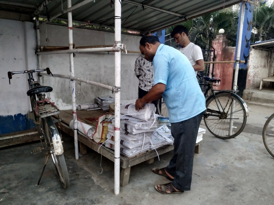 Anil Kumar organising the few bundles of newspapers to be distributed for the day outside the Tourist Lodge in Dimapur. (Morung Photo)