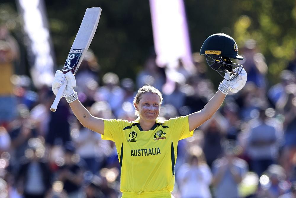 Australia's Alyssa Healy celebrates making 100 runs against England during the final of the ICC Women's Cricket World Cup match in Christchurch, New Zealand, Sunday, April 3, 2022. (Martin Hunter/Photosport via AP)
