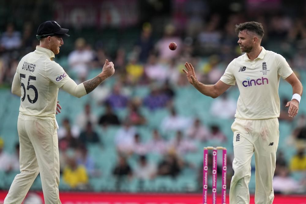 FILE - England's Ben Stokes, left, tosses the ball to teammate James Anderson during their Ashes cricket test match against Australia in Sydney, Jan. 5, 2022. Veteran fast bowlers James Anderson and Stuart Broad were recalled to the England test squad on Wednesday Ma 18, 2022, under new captain Ben Stokes. (AP Photo/Rick Rycroft, File)