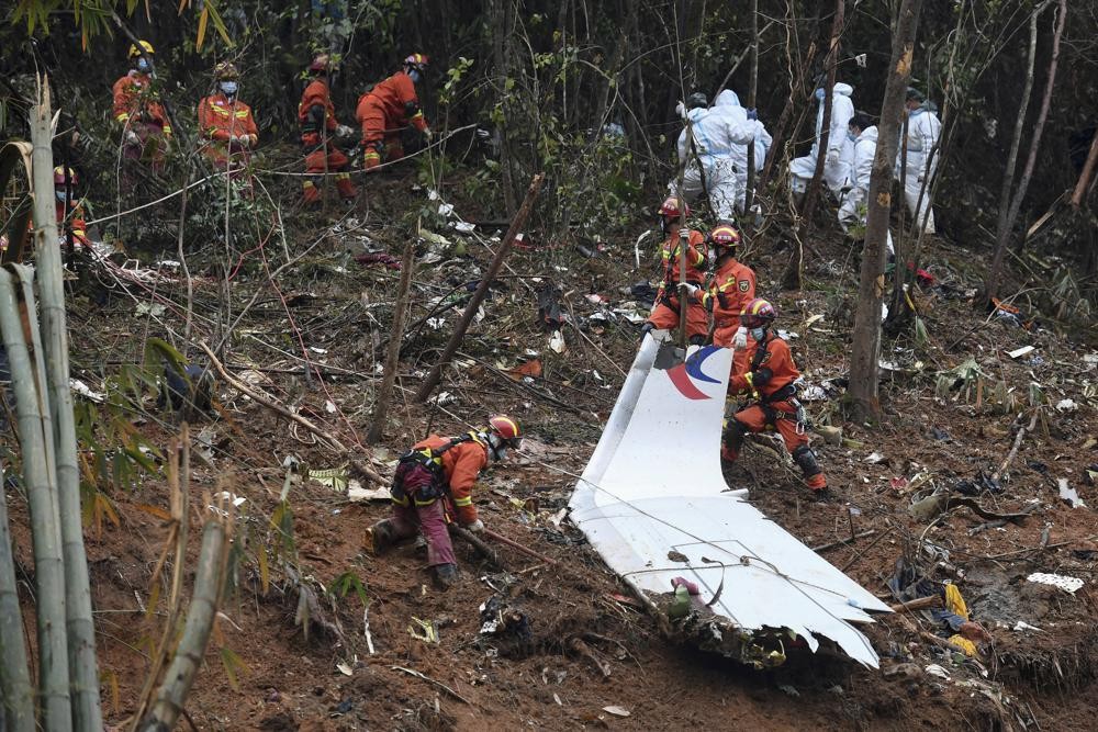FILE - In this photo released by Xinhua News Agency, search and rescue workers search through debris at the China Eastern flight crash site in Tengxian County in southern China's Guangxi Zhuang Autonomous Region on March 24, 2022. China said Wednesday, May 18, that U.S. investigators haven’t released any information about the cause of a China Eastern Airlines jetliner crash in March after The Wall Street Journal reported its flight data recorder indicated someone pushed the Boeing 737-800 into a steep dive. (Lu Boan/Xinhua via AP, File)