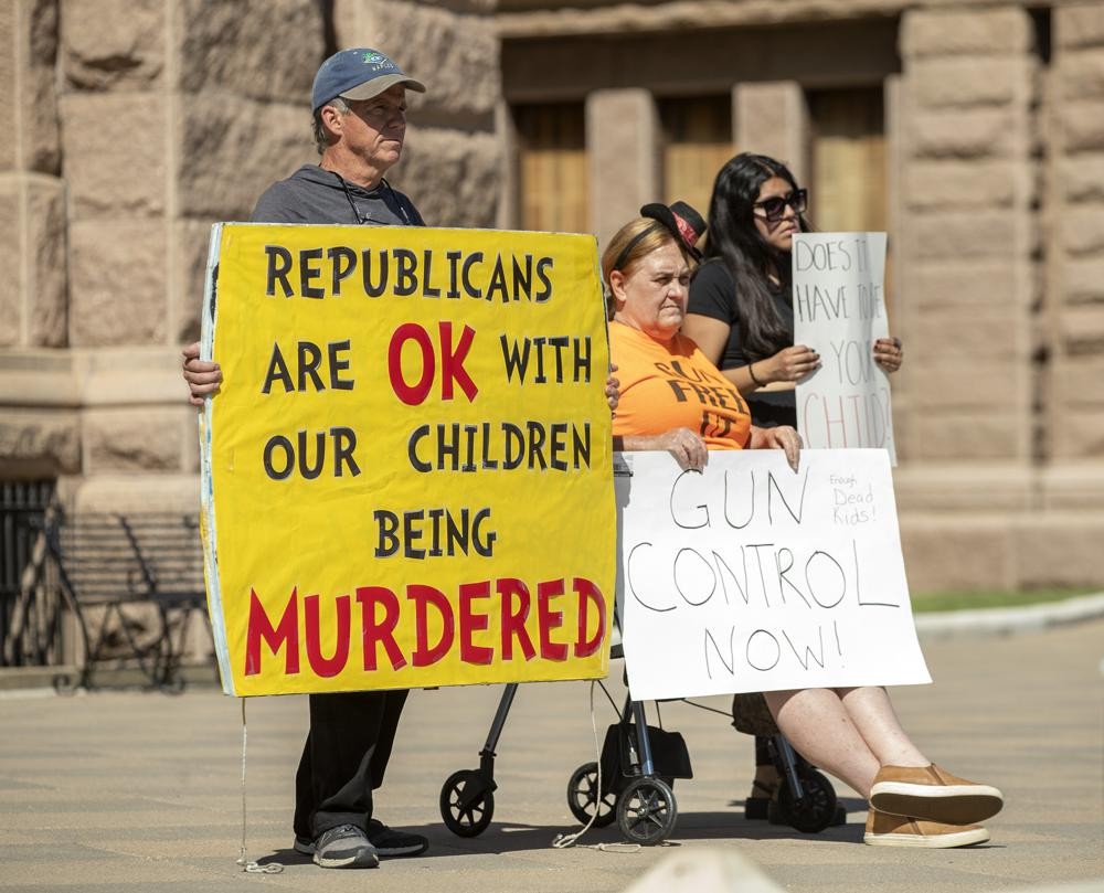 People hold signs during a protest at the Capitol in Austin, Texas, on Wednesday May 25, 2022, after a mass shooting at an elementary school in Uvalde. (Jay Janner/Austin American-Statesman via AP)