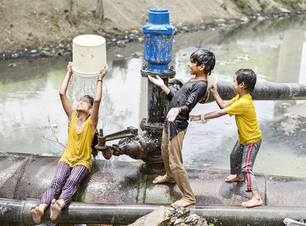 Children play with water to beat the heat on a hot summer afternoon, in New Delhi on May 1. (PTI Photo)