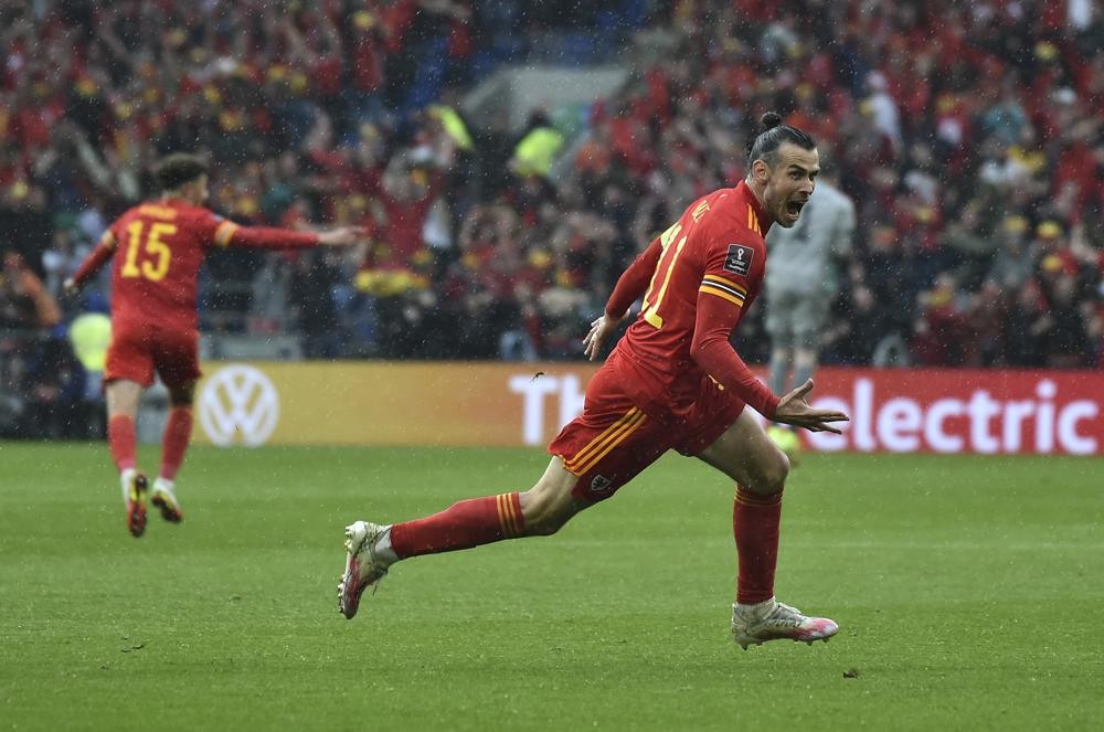 Wales Gareth Bale, right, celebrates after scoring his side's opening goal during the World Cup 2022 qualifying play-off soccer match between Wales and Ukraine at Cardiff City Stadium, in Cardiff, Wales, Sunday, June 5, 2022. (AP Photo/Rui Vieira)