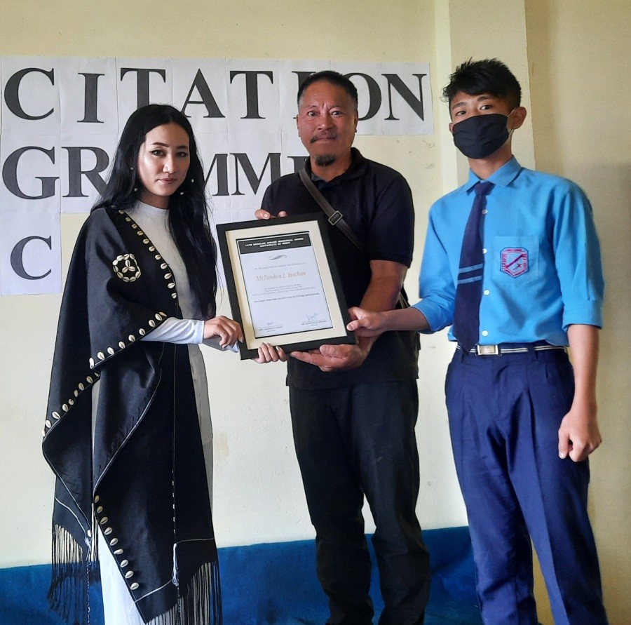 Alenuo Angami handing the award to Tumben L Yanthan on June 11.