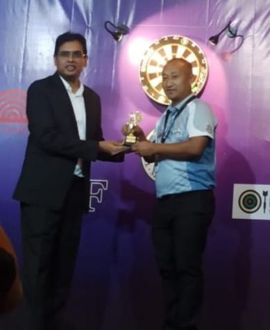 Vikehielie Suohu (R) receiving the trophy from an official.