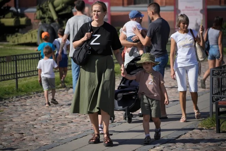A woman and her child wear T-shirts with the letter Z, which has become a symbol of support for the Russian military, as they walk on the grounds of the Artillery Museum in St. Petersburg, Russia, in August 2022. (AP Photo/Dmitri Lovetsky)