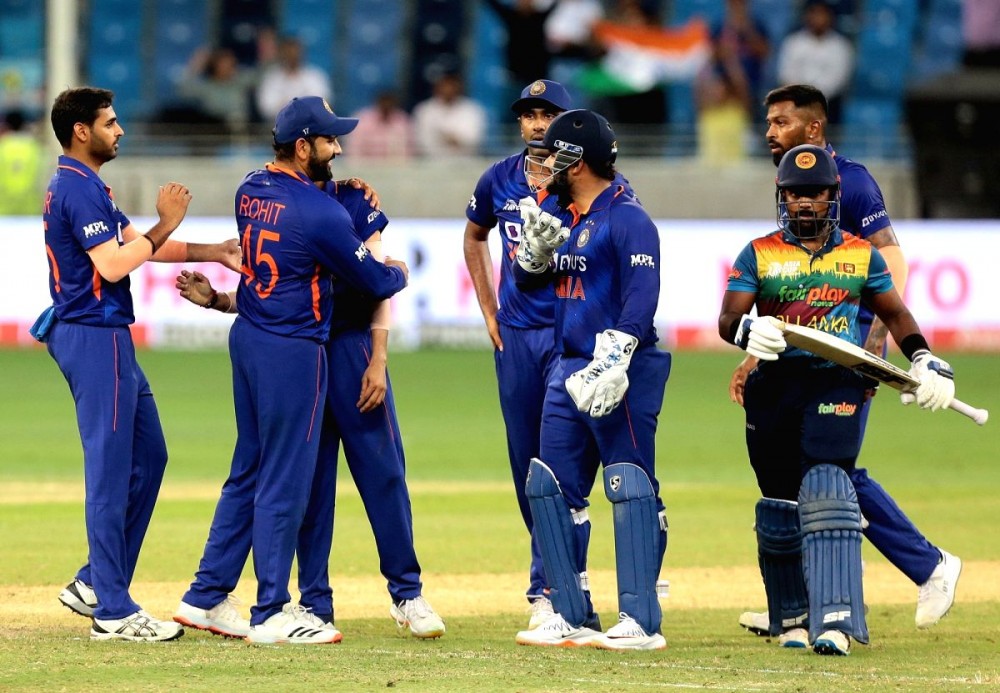 India's Yuzvendra Chahal, second left, celebrates with captain Rohit Sharma, left, the dismissal of Sri Lanka's Charith Asalanka, right, during the T20 cricket match of Asia Cup between Sri Lanka and India at Dubai International Stadium in Du. Image Source: IANS News