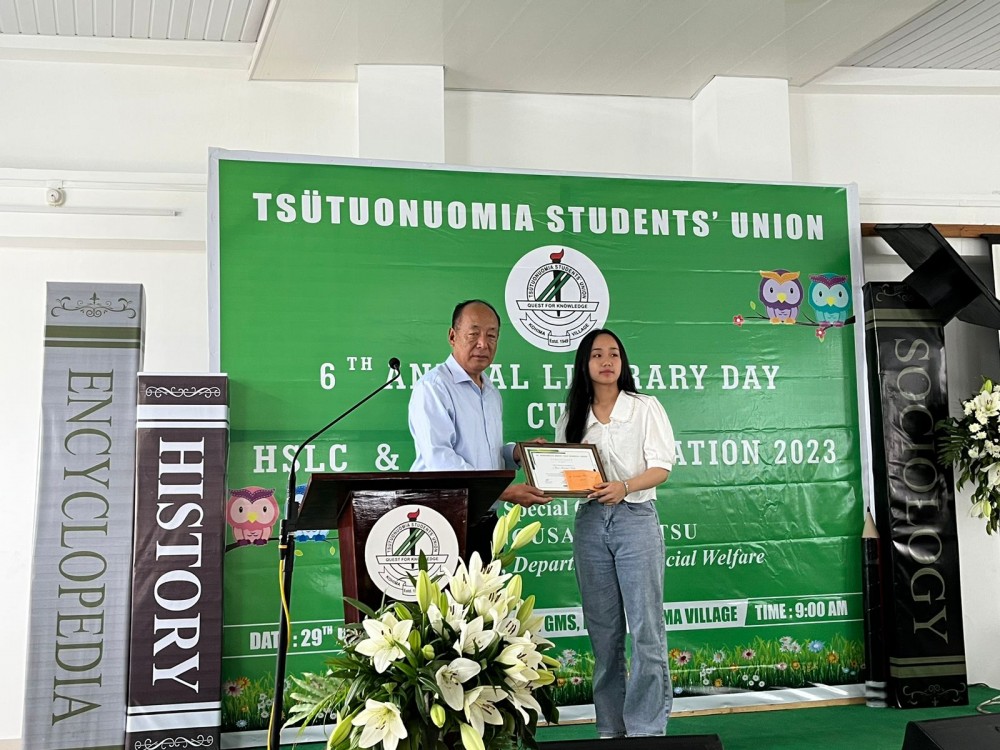 Dr Theyiephrezo hand over award to the best matriculate Neiseinuo Suohu.