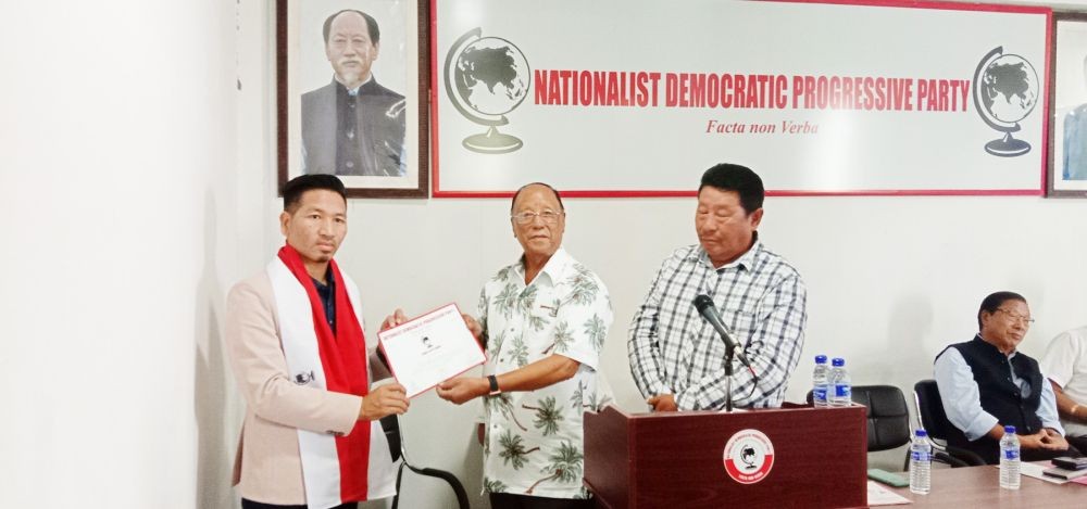 NDPP President Chingwang Konyak handing over the party ticket to Wangpang Konyak for the bye-election to the vacant 43 Tapi Assembly seat as Senior Vice President, Charlie Sekhose looks on, at the party headquarters in Chümoukedima on October 17. (Morung Photo)