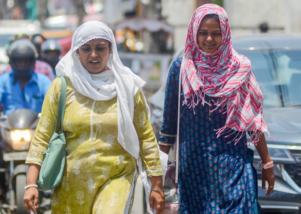 People carry a scarf to shield themselves from the scorching sun during a hot summer day in Chennai, Saturday, May 03, 2025. (Photo: IANS)