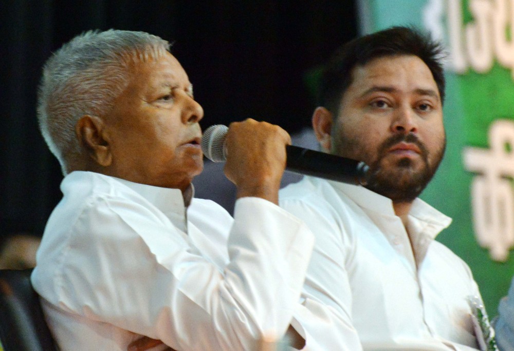 Rashtriya Janata Dal Chief Lalu Prasad addresses the newly formed State Council of Bihar Pradesh during a party meeting as Leader of Opposition in Bihar Legislative Assembly and his son, Tejashwi Yadav looks on at Gyan Bhavan in Patna on June 19, 2025. (IANS Photo)