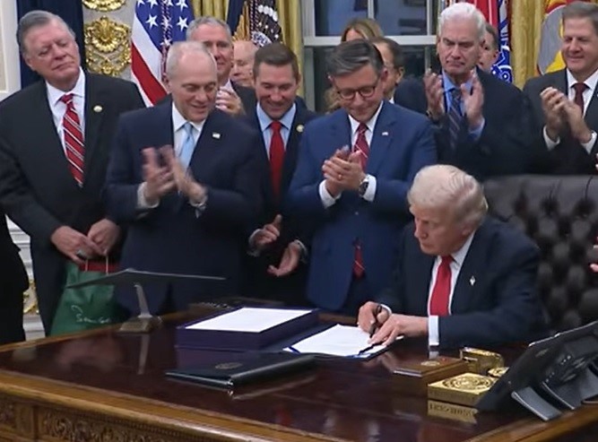 US President Donald Trump signs legislation ending the government shutdown on Wednesday, November 13, 2025. House of Representatives Speaker Mike Johnson is at his right. (Photo Source: White House)
