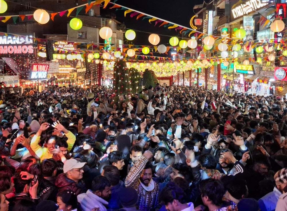 Tourists celebrate and dance on Mall Road on New Year’s Eve in Manali, Kullu on December 31, 2025. (IANS Photo)