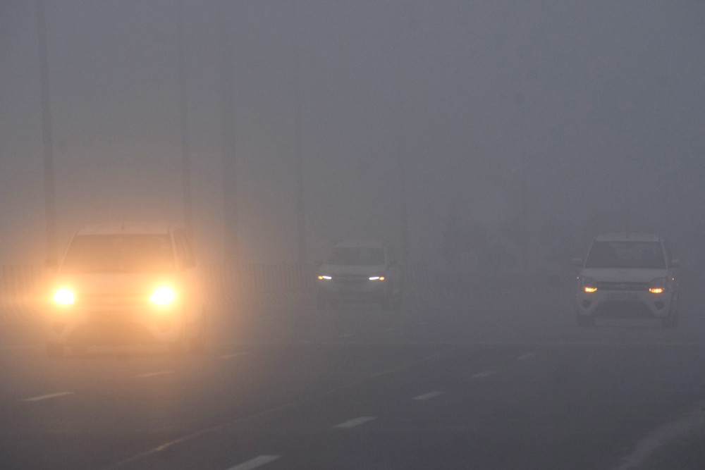 Vehicles move slowly with parking lights on amid extremely dense fog and near-zero visibility on the Dwarka-Mumbai Expressway in the Gurugram area, on the last day of 2025, December 31, 2025. (IANS Photo)
